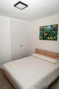 a bedroom with a bed and a painting on the wall at Piso en Antigua Casa de Correos in Molina de Aragón
