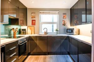 a kitchen with stainless steel cabinets and a sink at West Pier Beach - by Brighton Holiday Lets in Brighton & Hove