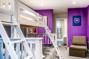 a room with a white bunk bed and purple walls at West Pier Beach - by Brighton Holiday Lets in Brighton & Hove