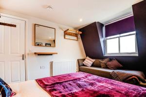 a room with a bed and a couch and a window at West Pier Beach - by Brighton Holiday Lets in Brighton & Hove +20 photos