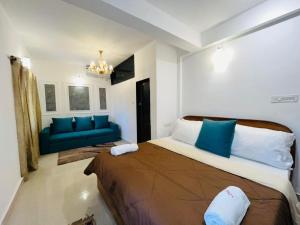 a bedroom with a large bed and a blue couch at Villa platinum 4 Bhk in Calangute +53 photos