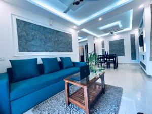 a living room with a blue couch and a table at Villa platinum 4 Bhk in Calangute
