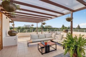 a patio with a couch and a table at OSOTUA Villa 18 Home Hotel Nanyuki 7 Bedrooms 14 Guests in Nanyuki
