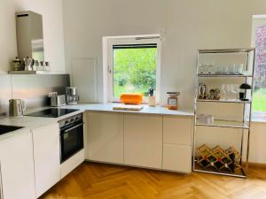 a kitchen with white cabinets and a window at Ferienwohnung Anstois in Kall