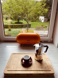 a wooden cutting board with a cup and a tea kettle at Ferienwohnung Anstois in Kall +62 photos