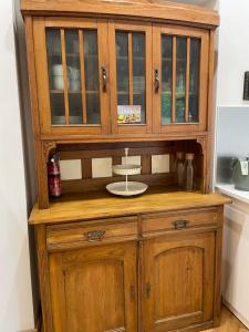 a wooden hutch with glass doors in a kitchen at Ferienwohnung Anstois in Kall