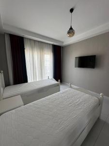 a bedroom with two white beds and a window at Serenity Residence duplex in Alanya +34 photos