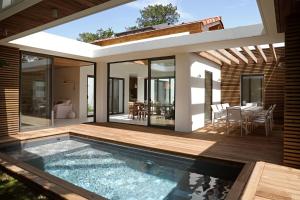 a house with a swimming pool and a deck at CLUQUE- Maisons de Vacances in Capbreton
