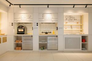 a kitchen with white walls and shelves with food at Leonardo Eden Hotel Amsterdam City Center in Amsterdam