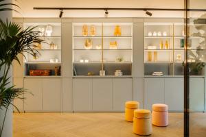 a room with a display case with cups and stools at Leonardo Eden Hotel Amsterdam City Center in Amsterdam