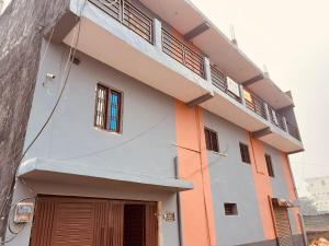a white and orange building with a balcony at BTS STAY- Singh Niwas in Ghaziabad