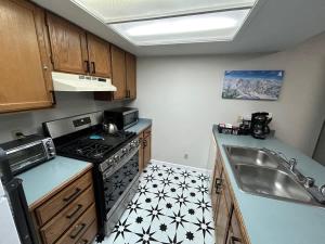 a small kitchen with a stove and a sink at The Meadows- Charming 1BD2BA Ski Condo in Kirkwood
