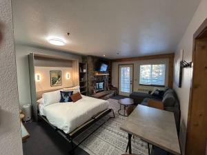 a bedroom with a bed and a living room at The Meadows- Charming 1BD2BA Ski Condo in Kirkwood