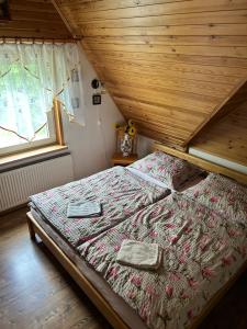 a bed in a room with a wooden ceiling at Beba in Heřmanovice