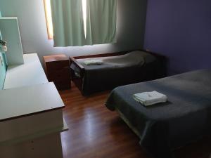 a small room with two beds and a window at Depto Castillo in El Bolsón