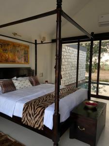 a bedroom with a canopy bed with a zebra print bedspread at Gulab Bagh Jawai in Jawāi Bāndh