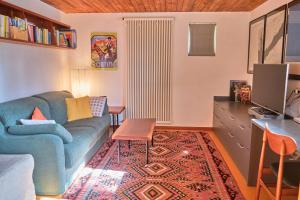 a living room with a blue couch and a desk at Chalet di design vista Pelmo - Chalet dei Brisi in Borca di Cadore