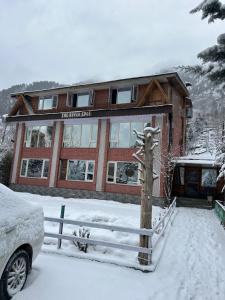 a house in the snow with a car parked in front at The River Edge in Pahalgām