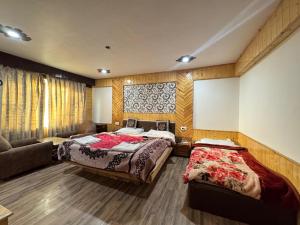 a bedroom with two beds and a couch at The River Edge in Pahalgām