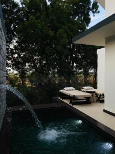 a swimming pool with a fountain next to a building at Gulab Bagh Jawai in Jawāi Bāndh