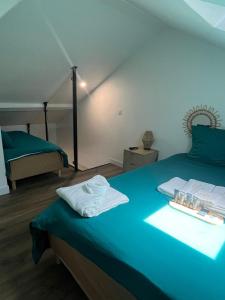 a bedroom with a blue bed with towels on it at Les Sources Vichy in Vichy