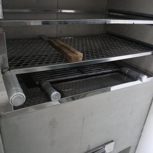 a drawer of an oven with a cutting board in it at Casa central com piscina! in Guaratuba
