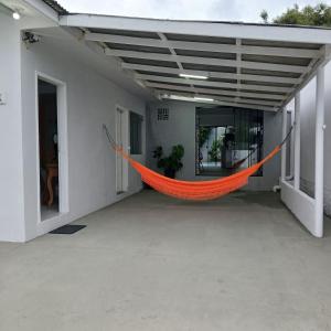 an orange hammock hanging from the side of a building at Casa central com piscina! in Guaratuba