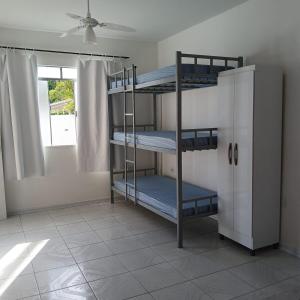 a room with three bunk beds and a window at Casa central com piscina! in Guaratuba +90 photos