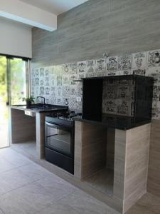 a kitchen with a stove and a counter top at Casa central com piscina! in Guaratuba