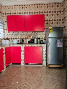 a kitchen with red cabinets and a refrigerator at Gifted Estates in Accra