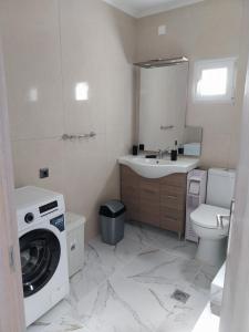 a bathroom with a washing machine and a washer at Paradis Studios in Archangelos +92 photos