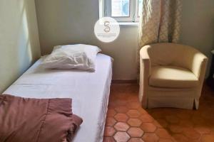 a small bedroom with a bed and a chair at Arène Arles Centre in Arles