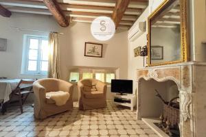 a living room with two chairs and a fireplace at Arène Arles Centre in Arles +10 photos