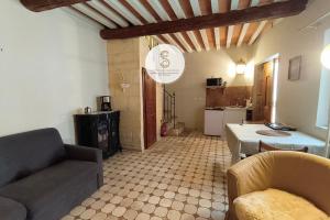 a living room with a couch and a kitchen at Arène Arles Centre in Arles
