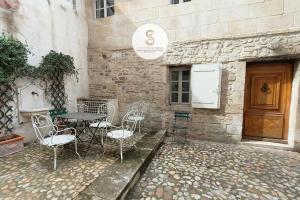 a table and chairs sitting outside of a building at Arène Arles Centre in Arles