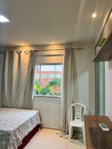 a bedroom with a bed and a chair and a window at Casa completa com 3 quartos,ar e garagem in Sobral +41 photos