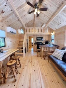 a log cabin living room with a ceiling fan at Cozy Coastal Cabin 1 in Steuben