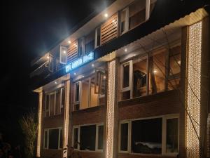 a building with a blue sign on it at night at The River Edge in Pahalgām
