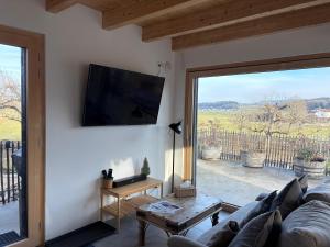 a living room with a couch and a large window at L'hôtât di loup in Courtedoux