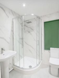 a white bathroom with a shower and a sink at Lincoln Manor 5BR in Peterborough