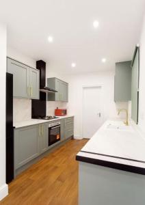 a kitchen with white cabinets and a white counter top at Lincoln Manor 5BR in Peterborough