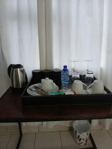 a tray with cups and a bottle of water on a table at DigiStay in Simonʼs Town