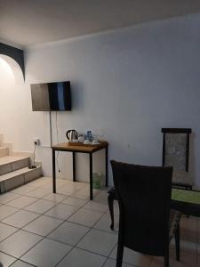 a living room with a table and a chair at DigiStay in Simonʼs Town