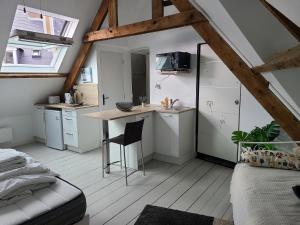 a kitchen with white cabinets and a desk in a room at Le nid de Marceline in Lannion
