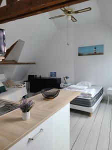 a room with two beds and a counter with a table at Le nid de Marceline in Lannion