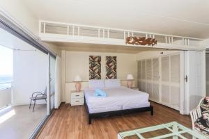a bedroom with a white bed and a balcony at Ilikai Tower 1842 in Honolulu