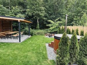 a garden with a picnic table and a gazebo at Dom Kacprowy - Brzegi Lasu - dwa apartamenty na wyłączność z ogrodem in Lipnica
