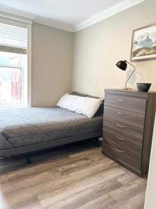 a bedroom with a bed and a dresser and a window at 92179 Newfoundland & Labrador Limited in St. John's