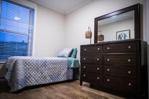 a bedroom with a dresser and a mirror at 92179 Newfoundland & Labrador Limited in St. John's +3 photos