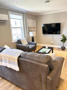 a living room with a brown couch and a tv at 92179 Newfoundland & Labrador Limited in St. John's